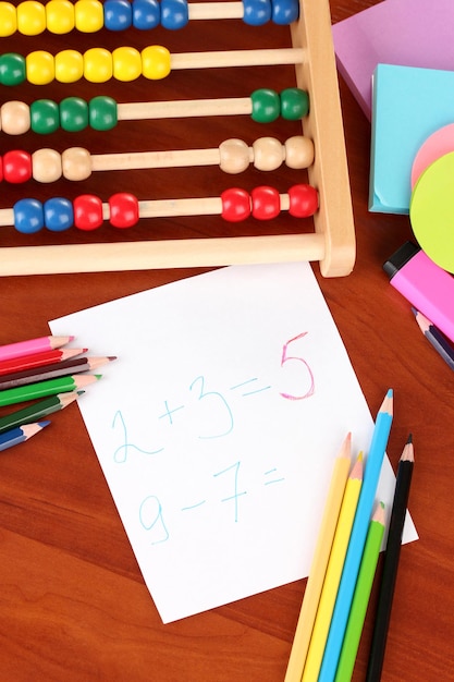 Toy abacus note paper pencils on bright background