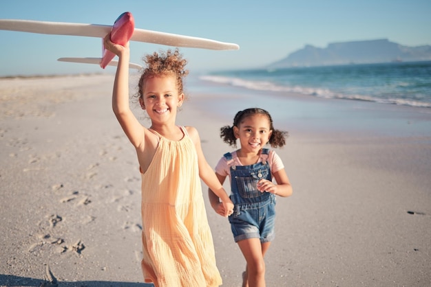 Toy airplane beach and children running with a happy sun and joy mindset in the nature sun Kids girls and siblings playing in the summer sunshine together with a smile happiness and fun time