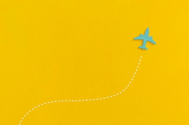 Toy airplane on a yellow background. Top view. Flat lay.