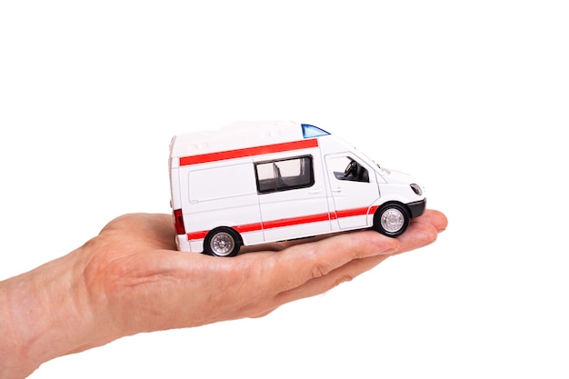 Toy ambulance car on palm isolated on white background