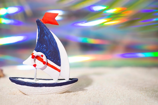 Toy boat and on white sea sand vacation concept by the sea with free space for text