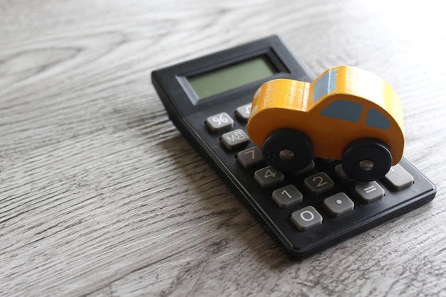 Toy car and calculator with copy space for text Car insurance buy sell repair and rent concept