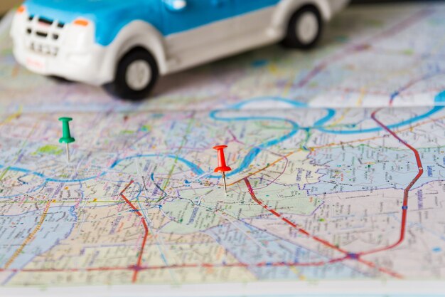 Photo toy car and push pin on the map. travelling concept. shallow depth of field.