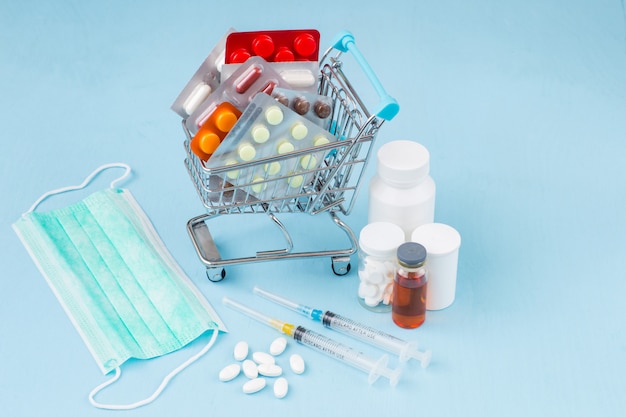 Toy cart full of packing tablets, next to syringes, mask and medicines