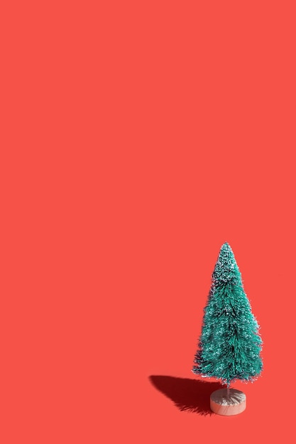 Toy christmas tree on a red background funny green artificial christmas tree