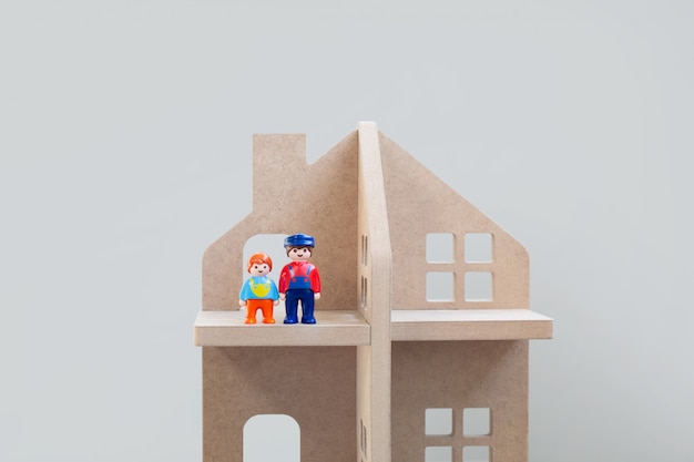 Toy figures of dad and son standing next to each other in a wooden house