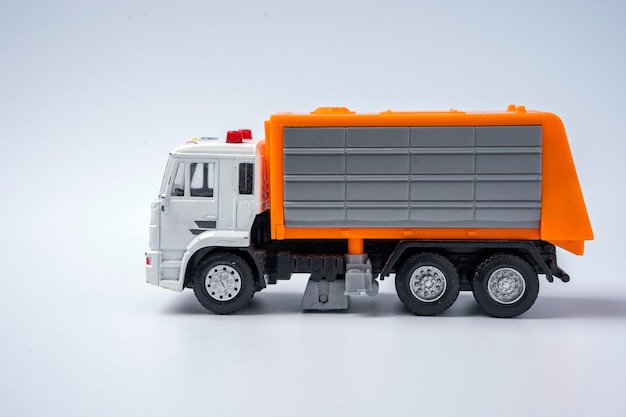 A toy garbage truck with an orange body on a white background