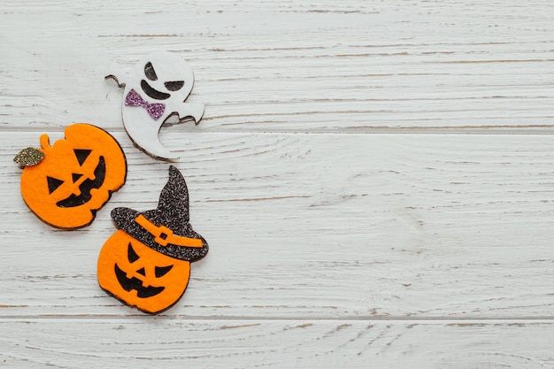 Toy ghost and pumpkin Jack made of felt on a wooden table Halloween decor