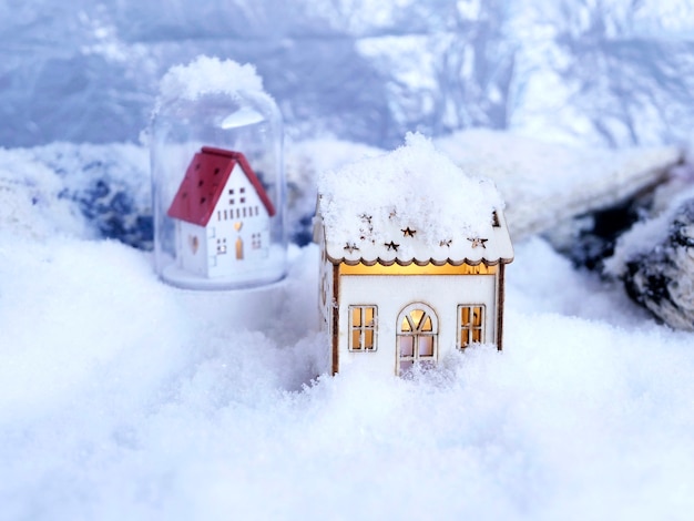 Toy house on a background of snow winter the concept of home comfort