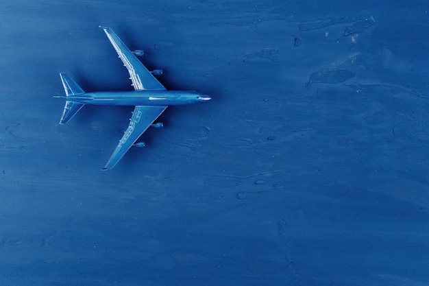 Toy plane on classic blue background, top view