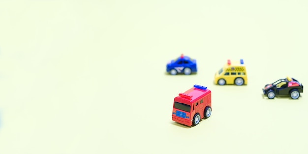 Toy plastic little cars on a light yellowish background