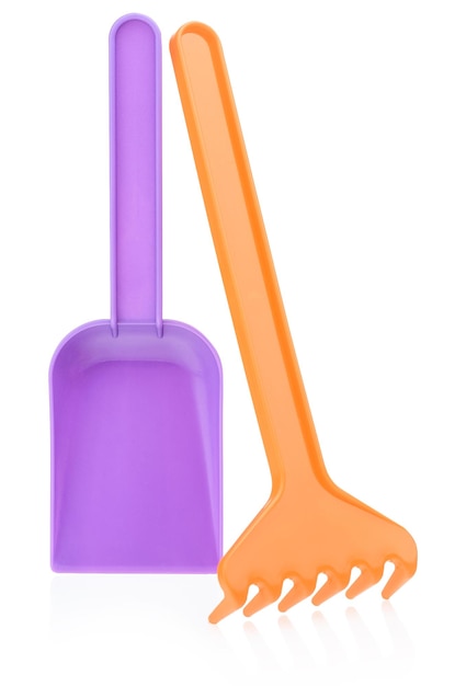 Toy rake and shovel made of plastic on a white background Children's shovel and rake for playing in the sandbox or on the beach Early childhood development