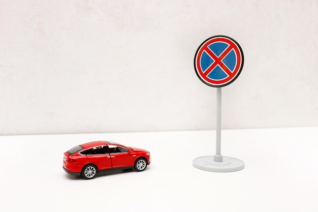 toy red car in front of a road sign no stopping with copy space