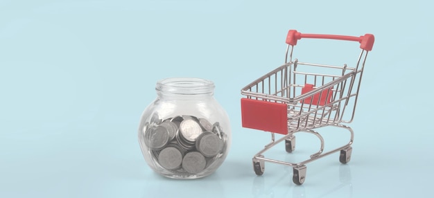 Toy shopping cart with coins and Piggy bank. Consumer society trend