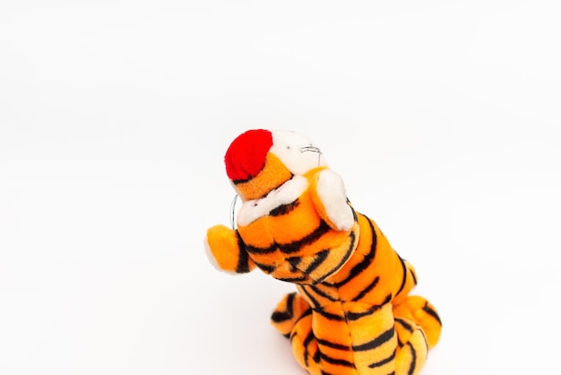 Toy striped cute tiger a symbol of the New year soft orange toy tiger on a white isolated backgroundCopy space closeup selective focus The concept of welcome to 2022Back view