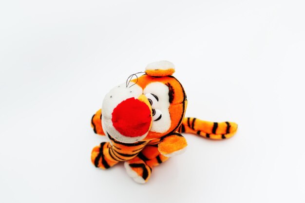 Toy striped cute tiger a symbol of the New year soft orange toy tiger on a white isolated backgroundCopy space closeup selective focus The concept of welcome to 2022Top view