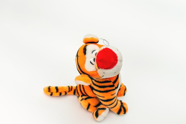 Photo toy striped cute tiger a symbol of the new year soft orange toy tiger on a white isolated backgroundcopy space closeup selective focus the concept of welcome to 2022top view