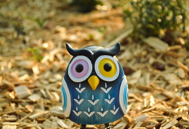 Photo a toy of a surprised blue owl with multicolored eyes closeup