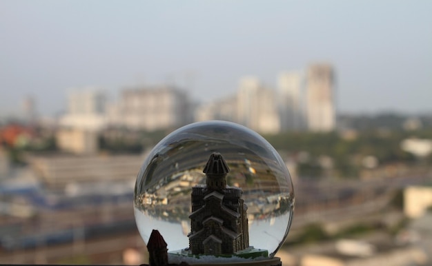 Toy tower in crystal glass ball with real cityscape soft focus