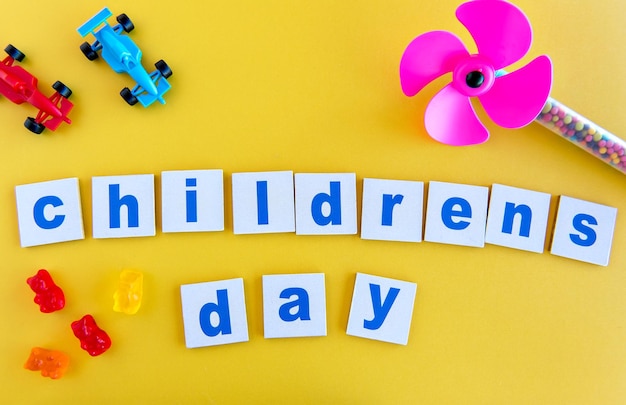 Toys and candies on a yellow background happy children's day