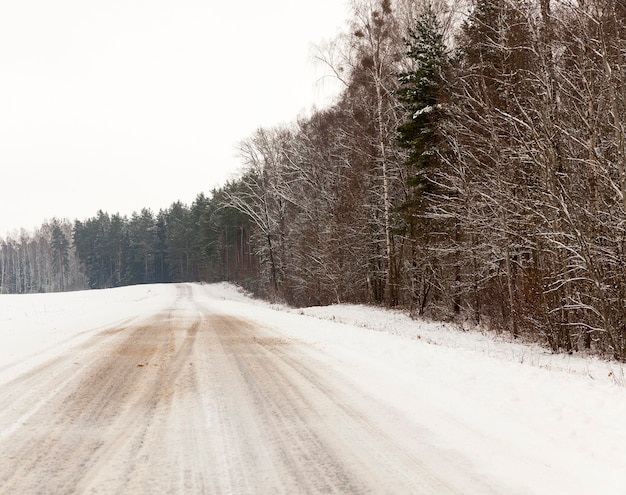 Traces of the tread on the snow, Snow covered in the winter season of the road,  taken close-up, Sky and trees in the frame