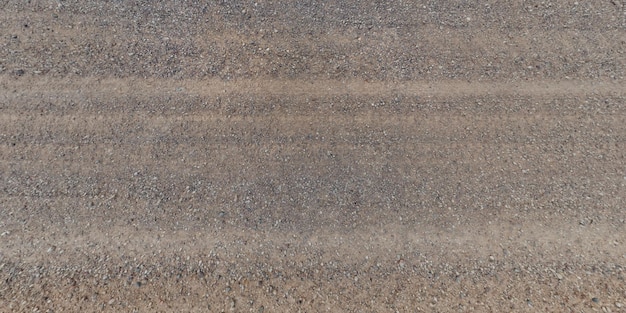 Photo traces of vehicle wheels on a dirt road gravel road