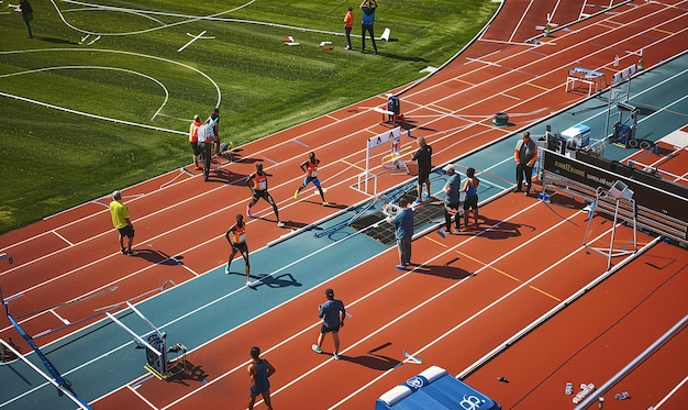 Photo a track with a blue box on it and people running around it