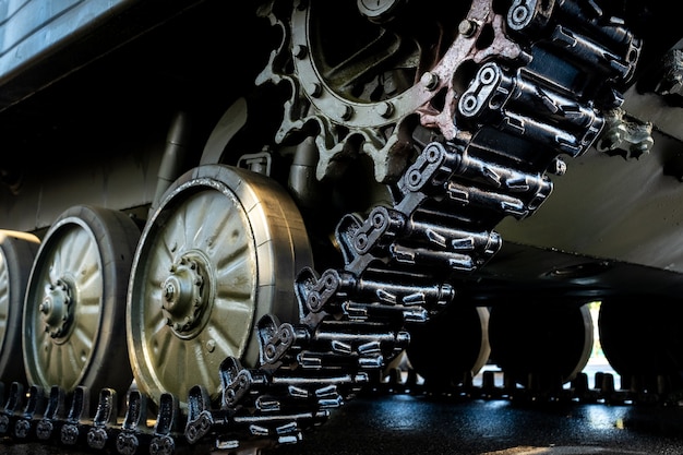 Tracked armor close-up. Black link tracks and large rubberized rollers. Chassis of an infantry fighting vehicle.