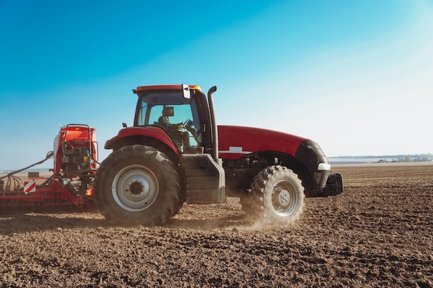 A tractor cultivates a field in autumn. Tractor plowing fields preparing land for sowing.