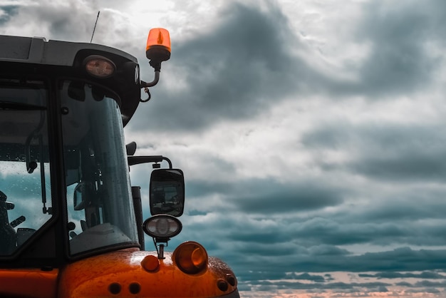 A tractor in the field against the background of the blue sky Copy space