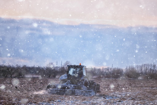 tractor in the field arable land winter agribusiness landscape seasonal work in a snowy field