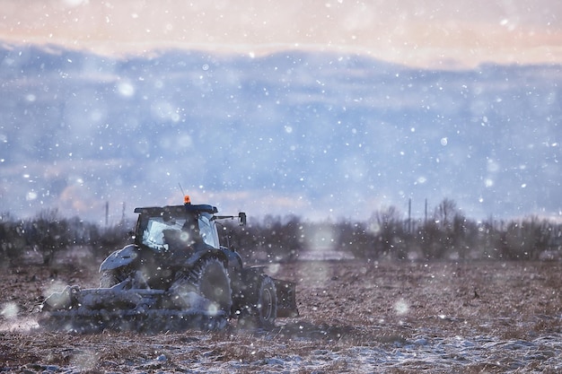 tractor in the field arable land winter agribusiness landscape seasonal work in a snowy field