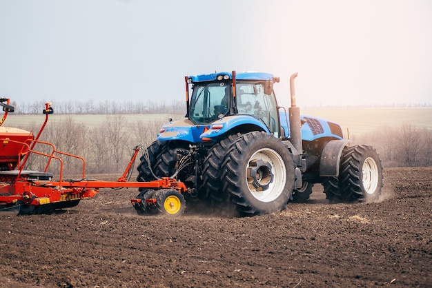 Tractor on the field farming in the village and village sowing in the spring agronomist on a combinexA