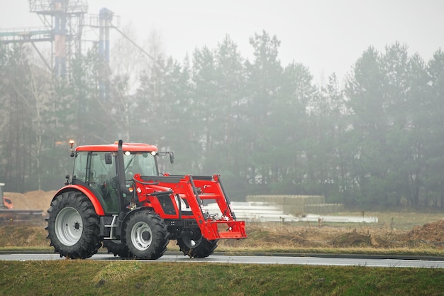 Photo tractor on foggy road in rural farming area