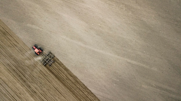 Tractor plowing field view from above aerial photo drone with place for inscription