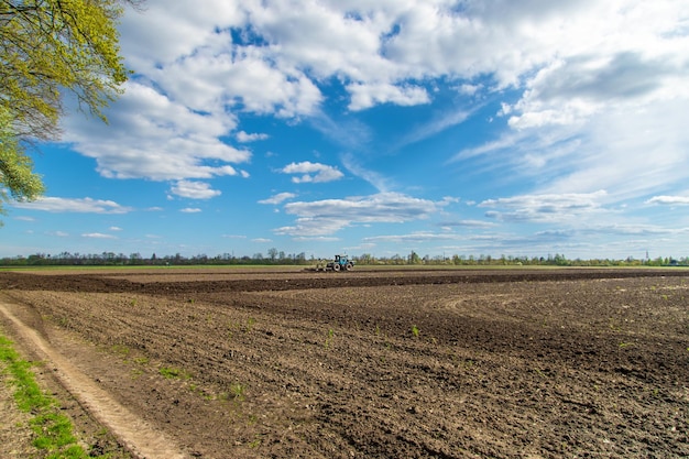 The tractor plows the soil in the field Selective focus