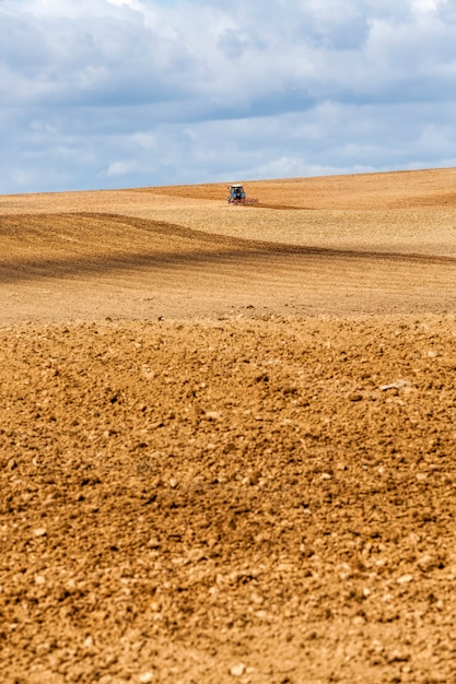 Tractor plows the soil in a field