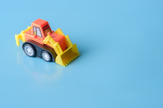 Tractor toy on blue background and copy space