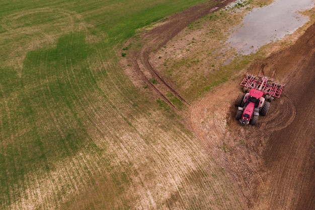 A tractor with a disc harrow plows a field Aerial photographyCopy space