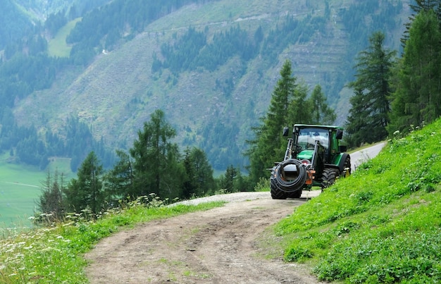 A tractor working in the fields high in the alp mountains of austria