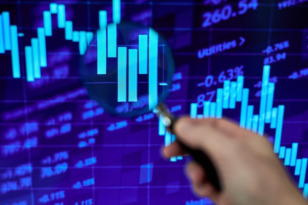 A trader looking at a stock market chart through a magnifying glass