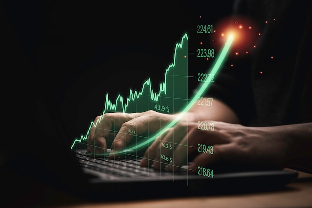 Trader using computer laptop with increasing virtual investment graph and chart for stock market analysis trend and technical by trader concept.