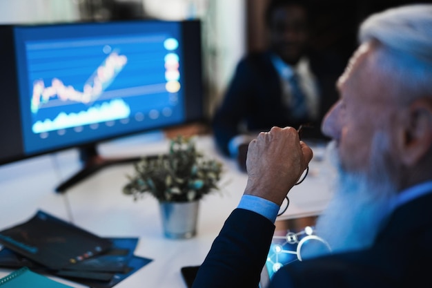 Traders people making stock market analysis inside hedge fund office  Focus on senior man arm