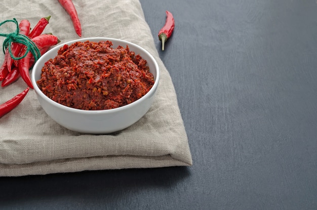 Traditional adjika hot chili pepper sauce paste harissa. Tunisia, georgian and arabic cuisine. Horizontal orientation.