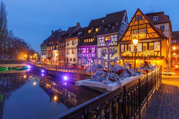 Traditional Alsatian half-timbered houses on the channel in Petite Venise, old town of Colmar, decorated and illuminated at christmas time, Alsace, France