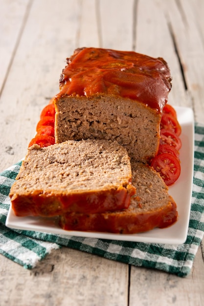 Traditional American meatloaf with ketchup on rustic wooden table