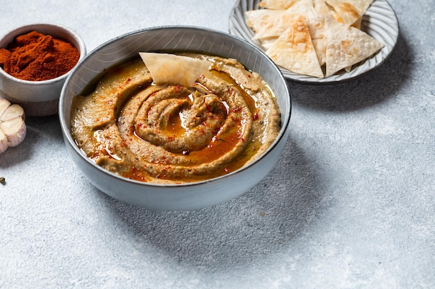 Traditional arabian eggplant dip baba ganoush with herbs and smoked paprika on light background Eggplant hummus Babaganush or eggplant caviar Baked eggplant Turkish eggplant dip