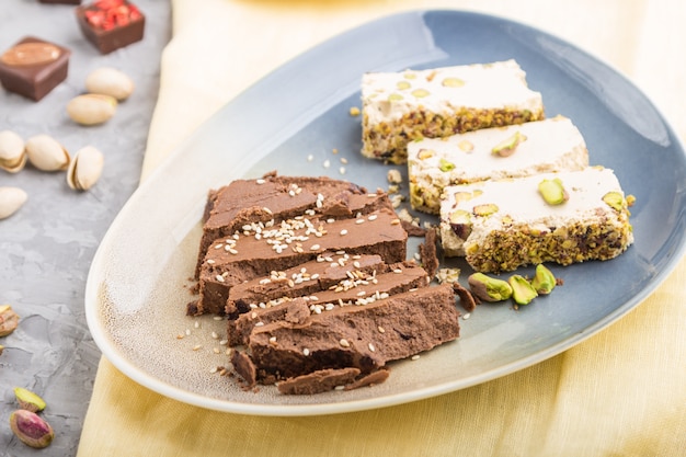 Traditional arabic sweets sesame halva with chocolate and pistachio and a cup of coffee. side view