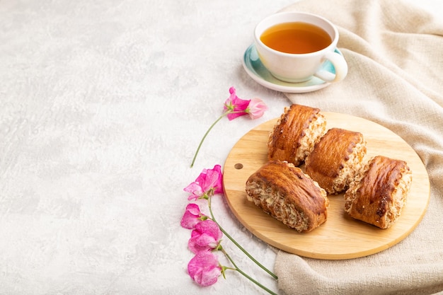 Traditional armenian dessert gata with cup of green tea on a gray concrete background side view copy space