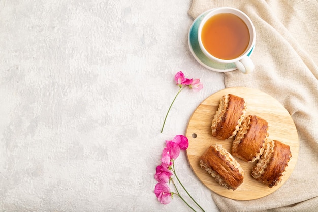 Traditional armenian dessert gata with cup of green tea on a gray concrete background top view copy space